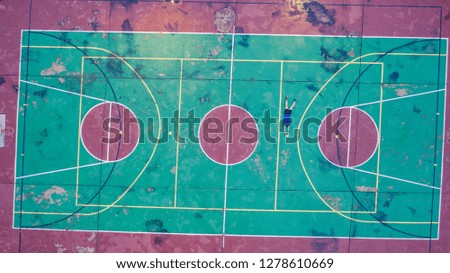 Top View Bird Eye View of Man lie sprawl on Colorful Pastel Basketball Court