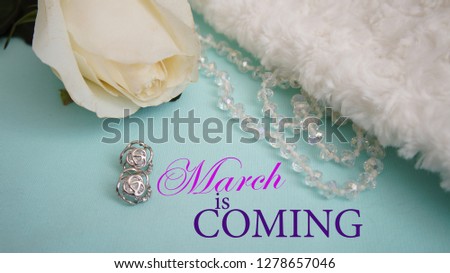 White rose, jewelry, fur and earrings. Inscription "March is coming". Concept of the international Women's Day. 
