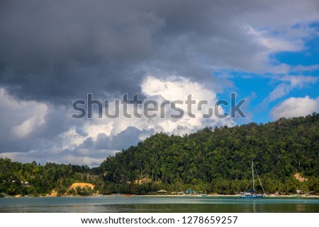 Tropical seaside landscape with sea water and greenery. Fishing boats and yacht in idyllic lagoon of tropical island. Exotic place for summer vacation. Philippines travel photo. Tropical island view