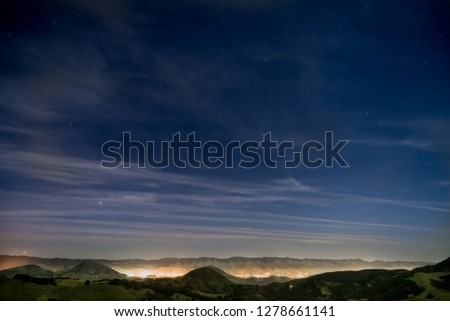 View of the city San Luis Obispo. Breathtaking view of a city, clouds, stars and mountains. 