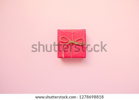 Red gift box on pink background. February 14 card, Valentine's day. 8 March, International Happy Women's Day. Flat lay, top view, copy space
