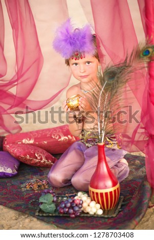 Little eastern fairytale princess holding a candlestick. Vertical photo.  