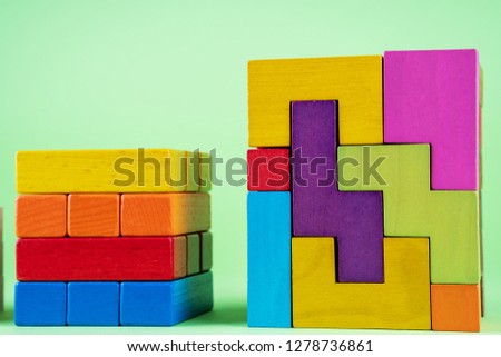 Growing graph from wooden cubes on green background. The concept of financial growth,  progress, development. Cubes of wooden multi-colored blocks. 

