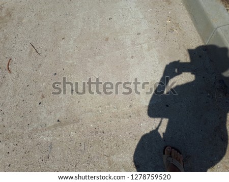 The shadow of a man in summer on asphalt