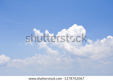 Bright cloudy in blue sky background among the sunlight shines down.