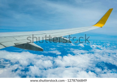 Wing of an airplane flying above the clouds.