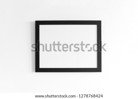 Black frame for paintings or photographs on the white wall. High resolution.