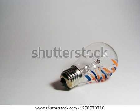                      Lightbulb with orange and blue stripes on white background.         