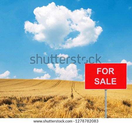 Farm with FOR SALE sign with cow in background