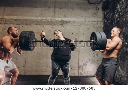 female strength concept.selfie with a huge barbell. funny blogger is taking photos at gym. interesting photo in unusual situation .