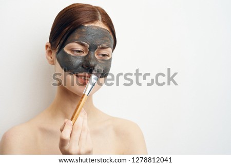 woman in a cosmetic mask in her hand makeup brush