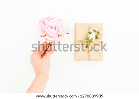 Woman hold peony flower and gift box on white background. Flat lay, top view. Valentines day.