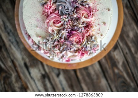 Cake with pink and violet cream on wood background. Pink and violet cake. Top view - Image