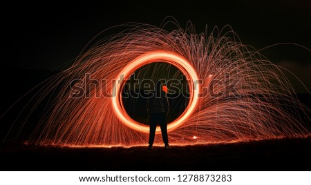 Night light time-lapse photography of fireworks, circular ring lights, red fireworks background