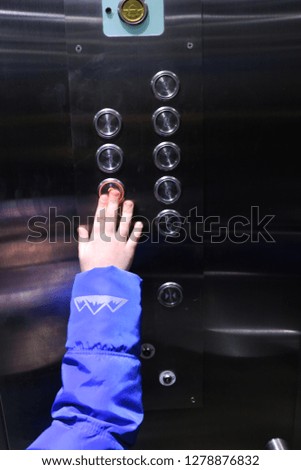 Elevator buttons. Boy's hand