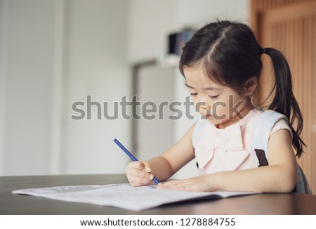 Back to school, Cute little girl painting a picture in home, Girl writing in notebook with pencil at her bedroom.