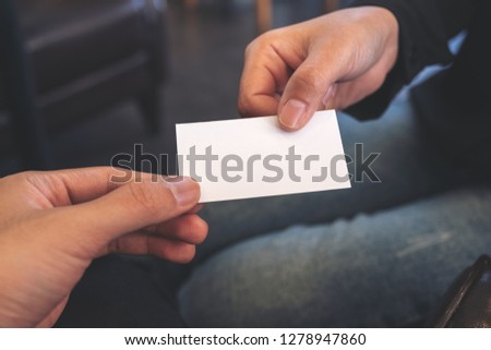 A woman holding and giving empty business card to someone