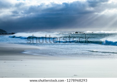 Scenic landscape picture of waves crashing on the beach on a summer evening at Camps bay in Cape Town, South Africa