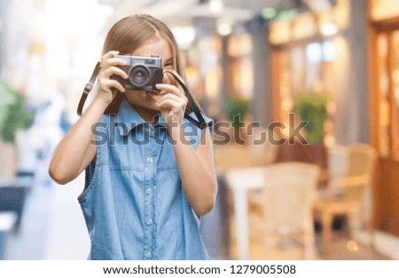 Young beautiful girl taking photos using vintage camera over isolated background with a happy face standing and smiling with a confident smile showing teeth