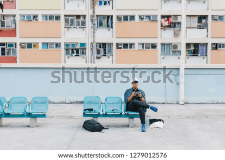 Man relax on bench at colorful pastel apartment windows