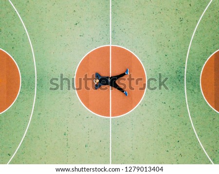 Top View Bird Eye View of Man lie sprawl on Colorful Pastel Basketball Court