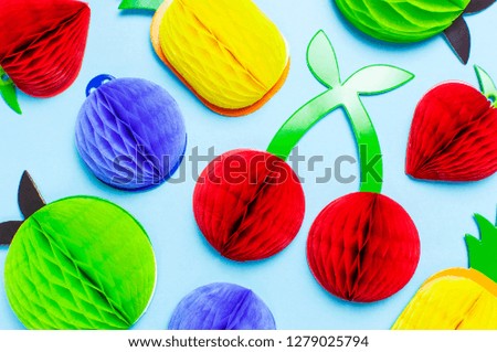 Flat lay bright tropical fruits of paper, strawberry, cherries, pineapple, apple, plum on blue background top view copy space. Minimalistic creative summer food concept, origami paper fruit 