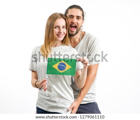 Happy couple in gray t-shirts with the flag of Brazil, isolated on white background. Fun people, man and woman.