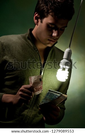 young man near a light bulb low consumption, concept of ecology and energy saving