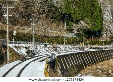 Railway track for local train with white snow fall in Japan.
