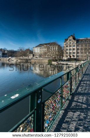 many different color and style locks and the wire railing of a bridge symbolizing long relationships and everlasting romantic love on a bridge in Zurich