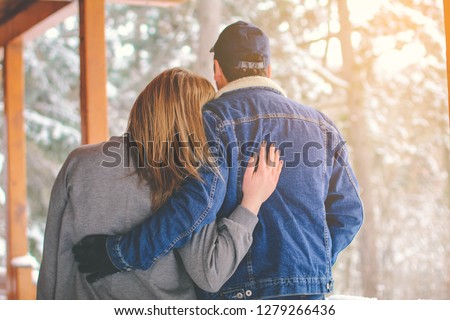 Back view of beautiful young couple cuddling in winter - Image

