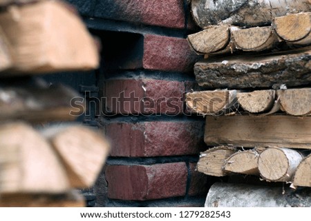 Birch firewood near the furnace firebox. Chipped logs lying near the stove of red brick