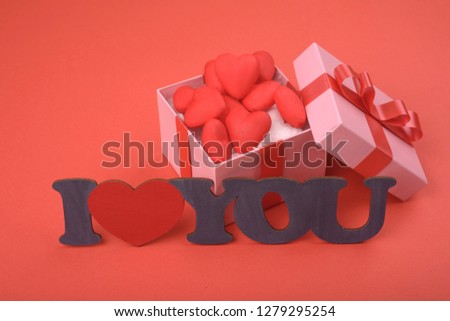 Valentines day. Pink gift box and plate i love you on red background