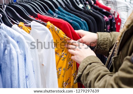 Buyer woman chooses clothes in store.