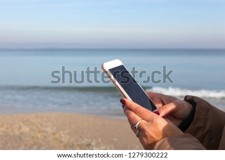 Woman Using Smart Phone On A Beach