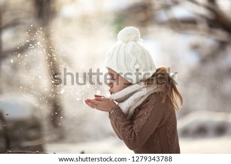 Funny girl and snow, closeup portrait. Winter and happy childhood