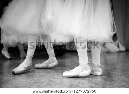 Ballerina is training in the dance hall. Close-up of a ballerina's legs in the dance hall. Black and white photography.