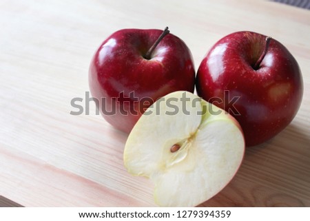 A close-up picture of red apples on a wooden surface