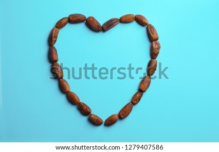 Frame made of sweet dried date fruits on color background, top view with space for text