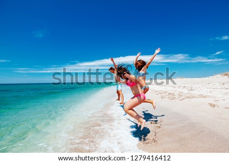 Teenage friends having fun on the beach. Summer vacations by the sea.