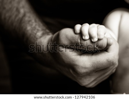 Father holding his son's hand - black and white photography