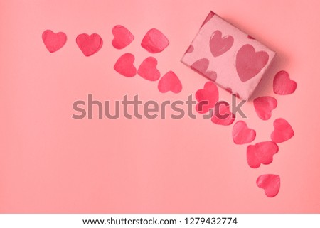 Gift in Kraft paper with red hearts on pink background with hearts. The Concept Of Valentine's Day. view from above . copy space.
