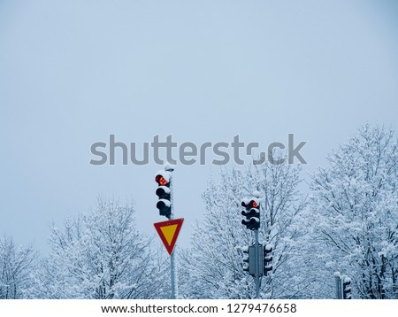 Traffic lights and sign covered with white snow