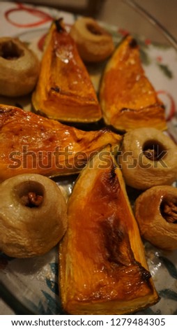 Juicy roasted pumpkins and apples with walnuts filling, food background