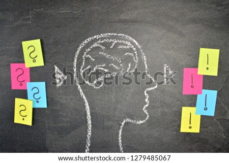 The silhouette of a head drawn with chalk on a dark stone surface as a concept and symbol for the thought process and the brainstorming for the unfolding of creativity and problem solving