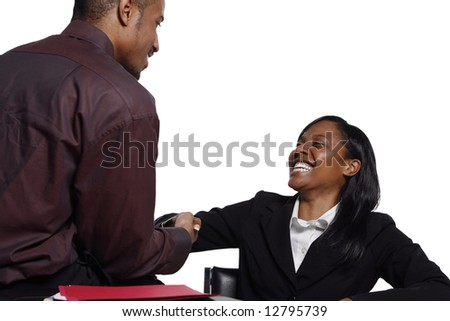 Male and female business colleagues smiling broadly and shaking hands