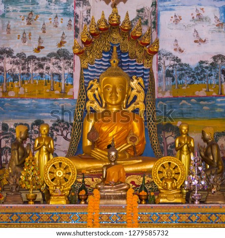 Buddha sitting on naga body and nine naga head protected. Thai church wall paintings as background at buddhist temple in Loei province, Thailand.