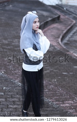 Modest fashion inspiration. Portrait of elegant lady. Women wearing grey hijab. Street style.