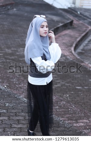 Modest fashion inspiration. Portrait of elegant lady. Women wearing grey hijab. Street style.