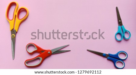 Colorful scissors on pink background
